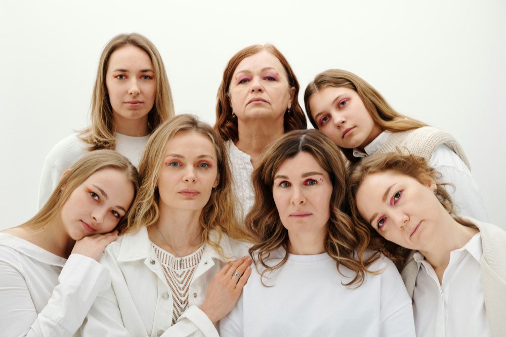 Seven women leaning into one another