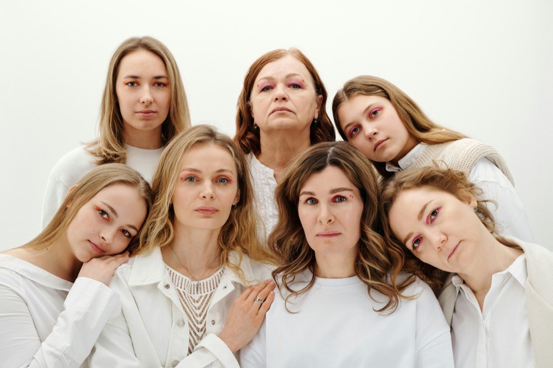 Seven women leaning into one another